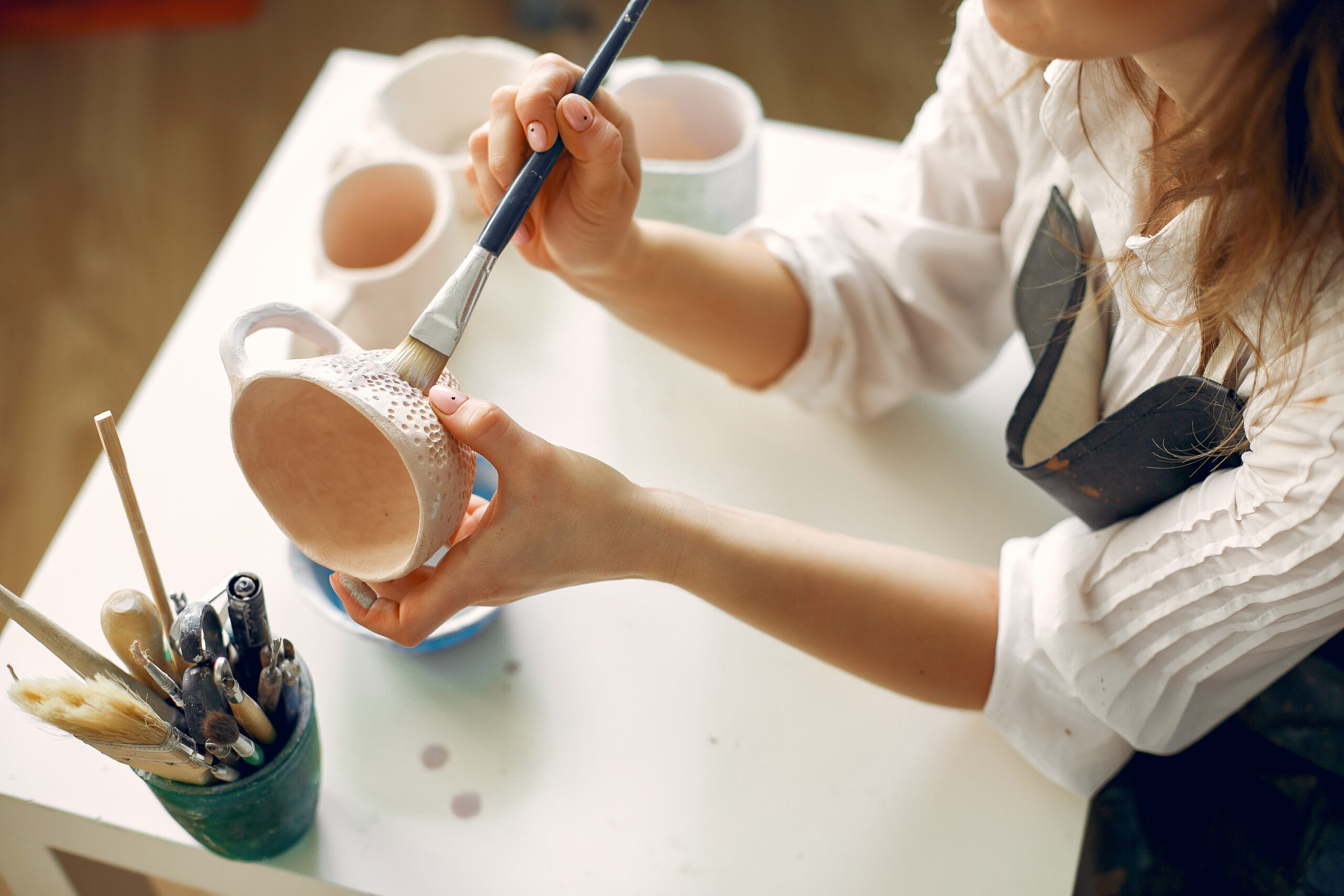 a young woman mpainting dishes in a pottery 2024 12 06 12 46 47 utc scaled